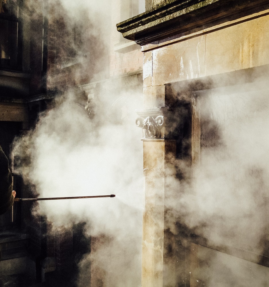 Steam cleaning being applied to a stone building.