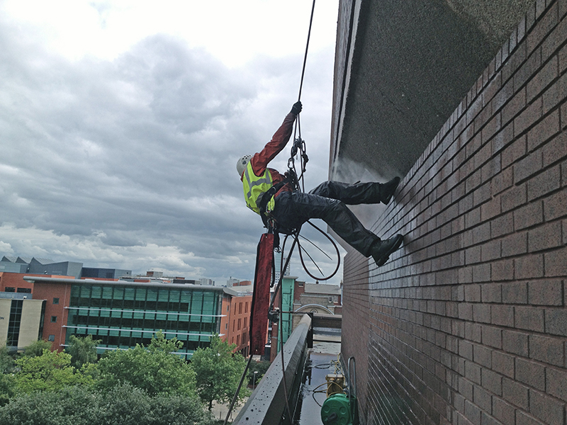 Industrial rope access cleaning on a brick building